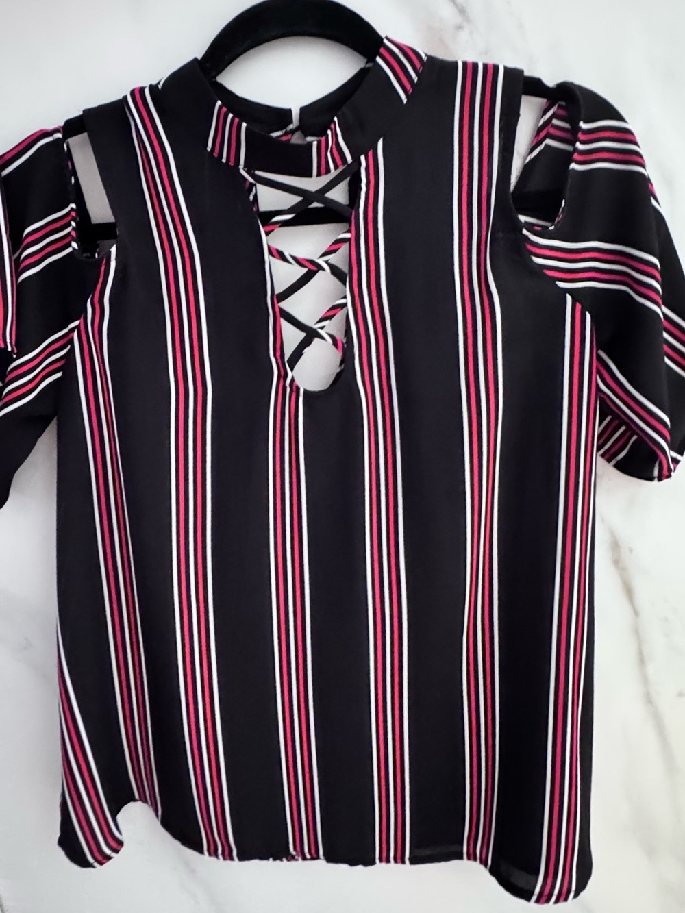 Black blouse with red and white stripes with shoulder and chest cutouts.